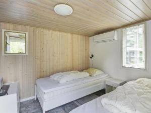 1 dormitorio con 2 camas en una habitación con paredes de madera en Holiday Home Pinja - 40km from the sea in SE Jutland by Interhome en Silkeborg