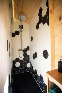 a bathroom with black and white tiles on the wall at L'encantada- Roulotte in Rieux