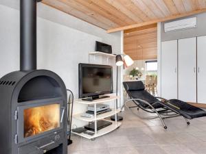 uma sala de estar com lareira e televisão em Holiday Home Ingbritt - 700m to the inlet in Western Jutland by Interhome em Tarm
