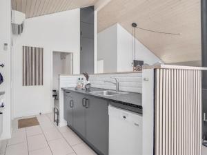 a kitchen with white cabinets and a sink at Holiday Home Asel - 4km from the sea in NW Jutland by Interhome in Brovst