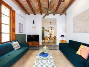 a living room with two blue couches and a tv at Spacious apartment in the Gothic in Barcelona
