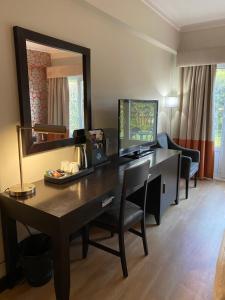 Cette chambre comprend un bureau et un miroir. dans l'établissement Hotel Inglaterra - Charme & Boutique, à Estoril