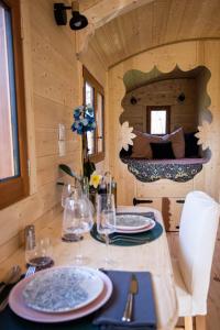 a table in a tiny house with plates and glasses at L'encantada- Roulotte in Rieux