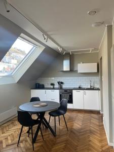 a kitchen and dining room with a table and chairs at Kong Oscars Apartments in Bergen