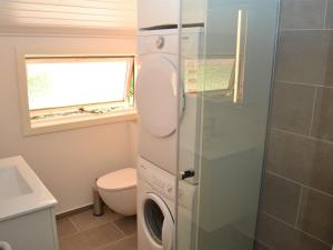 ein Badezimmer mit einem WC und einer Waschmaschine in der Unterkunft Holiday Home Carlene - 25km from the sea in Western Jutland by Interhome in Toftlund