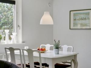 una mesa de comedor blanca con un bol de fruta. en Holiday Home Øthi in Western Jutland by Interhome, en Ribe