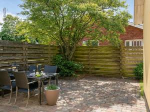 a patio with a table and chairs and a fence at Holiday Home Øthi in Western Jutland by Interhome in Ribe