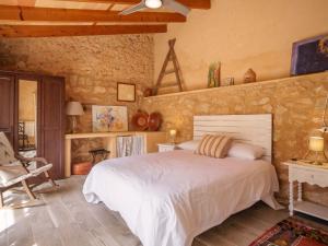 a bedroom with a bed and a stone wall at Holiday Home Can Salom by Interhome in Binissalem