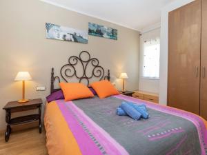 a bedroom with a large bed with orange and purple pillows at Holiday Home Eden Park 2 by Interhome in Miami Platja