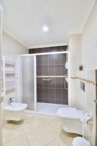 a bathroom with a shower and a toilet and a sink at Sweethome - Praia da Rocha in Portimão