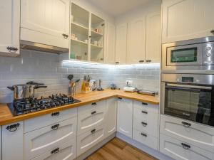 una cucina con armadi bianchi e piano cottura di Apartment Millenium by Interhome a Premia de Dalt