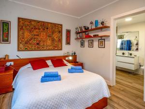 a bedroom with a large bed with blue pillows on it at Apartment Millenium by Interhome in Premia de Dalt