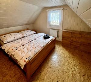 ein Schlafzimmer mit einem Bett, einer Kommode und einem Fenster in der Unterkunft Chata Barborka in Terchová