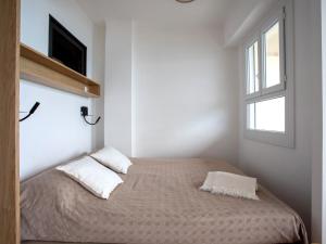 Apartment L'Angelina-2 by Interhome في كاجنيس سور مير: غرفة نوم بسرير وتلفزيون ونافذة
