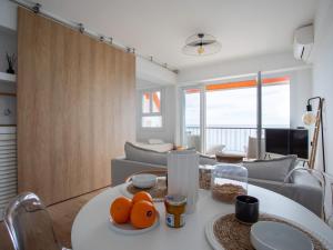 Apartment L'Angelina-2 by Interhome في كاجنيس سور مير: غرفة معيشة مع طاولة عليها برتقال