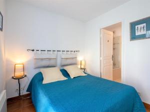 ein Schlafzimmer mit einem blauen Bett mit zwei Lampen in der Unterkunft Apartment Le Domaine de Figuière-2 by Interhome in Sainte-Maxime