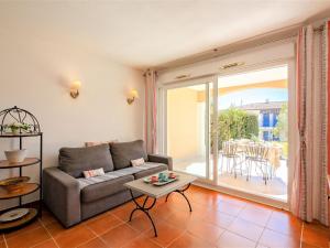 ein Wohnzimmer mit einem Sofa und einem Tisch in der Unterkunft Apartment Le Domaine de Figuière-2 by Interhome in Sainte-Maxime