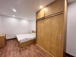 um quarto com uma cama e uma grande porta de madeira em An Nam Corner- Thanh Yen em Hanói