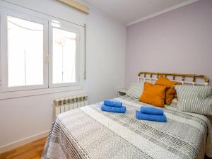 een slaapkamer met een bed met blauwe handdoeken bij Apartment Irule by Interhome in Sant Cebrià de Vallalta