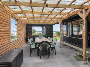 a patio with a wooden pergola and a table and chairs at Holiday Home Graa in SE Jutland by Interhome in Skanderborg