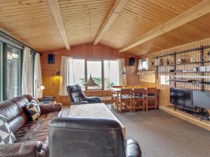 een woonkamer met een leren bank en een televisie bij Holiday Home Graa in SE Jutland by Interhome in Skanderborg