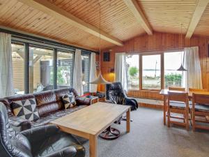 een woonkamer met een bank en een tafel bij Holiday Home Graa in SE Jutland by Interhome in Skanderborg