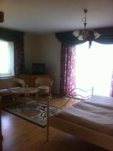 a bedroom with a bed and a table and a window at Hotel & Waldrestaurant Johannesruh in Wesenberg