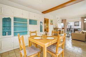 een keuken en een woonkamer met een houten tafel en stoelen bij La Marina Apartments in Platja  d'Aro