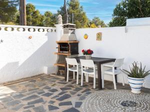 a patio with a table and chairs and a grill at Villa Villa Casalot 9 by Interhome in Miami Platja