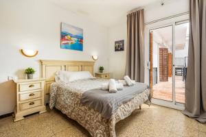 een slaapkamer met een bed en een glazen schuifdeur bij La Marina Apartments in Platja  d'Aro