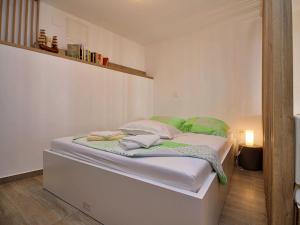ein weißes Bett in einem Zimmer mit Spiegel in der Unterkunft Apartment Borka-3 by Interhome in Trogir