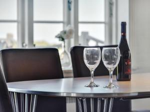 una mesa con una botella de vino y dos copas de vino en Holiday Home Ejna in Western Jutland by Interhome, en Bredebro