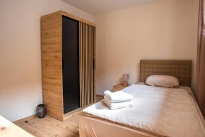 a bedroom with a bed with two towels on it at Landena Apartments Lendava in Lendava