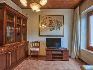 un salon avec une télévision et un bureau avec une chaise dans l'établissement Holiday Home Pina & Rosy-2 by Interhome, à Porlezza