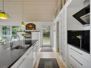 uma cozinha com armários brancos e bancadas pretas em Holiday Home Ødger - 150m to the inlet in The Liim Fiord by Interhome em Åbybro