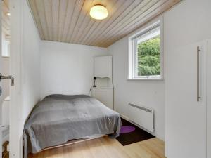 a white bedroom with a bed and a window at Holiday Home Ødger - 150m to the inlet in The Liim Fiord by Interhome in Åbybro