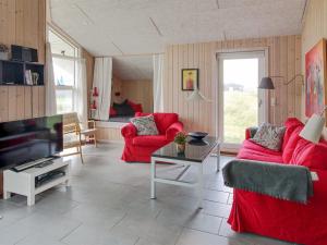 sala de estar con sofás rojos y TV en Holiday Home Griselda - 700m from the sea in NW Jutland by Interhome en Torsted