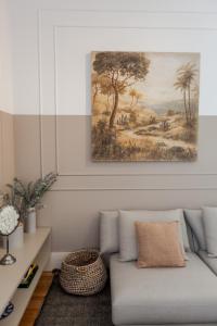 un soggiorno con un divano e un quadro sul muro di FLH Amazing Praça Comércio Design Flat a Lisbona