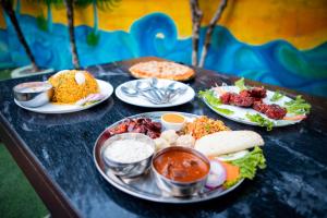 a table topped with plates of food and dips at Gypsy Hostel & Backpackers in Pokhara