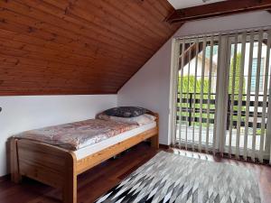 a bedroom with a bed and a large window at Village Light House in Omšenie