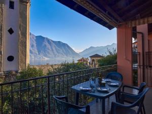 a table on a balcony with a view of the mountains at Holiday Home Tower Bell House by Interhome in Isola Comacina