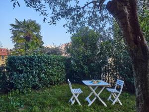 a table and two chairs sitting next to a tree at Holiday Home Tower Bell House by Interhome in Isola Comacina