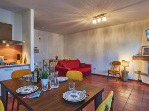 a living room with a table and a red couch at Holiday Home Tower Bell House by Interhome in Isola Comacina