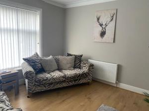 a living room with a couch and a deer on the wall at Amazing Two Bedroom Apartment - SR in Southport