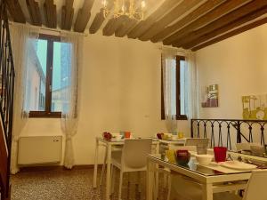 een eetkamer met tafels en stoelen en een kroonluchter bij Residenza Corte Antica in Venetië
