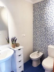 een badkamer met een wastafel, een toilet en een spiegel bij Ático Alquiler Mondaríz Paraiso del agua. Vistas espectaculares in Mondariz
