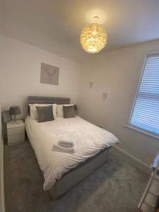 a bedroom with a bed and a chandelier at Amazing Two Bedroom Apartment - SR in Southport