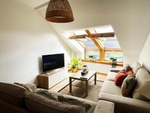 een woonkamer met een bank en een tv bij Ático Alquiler Mondaríz Paraiso del agua. Vistas espectaculares in Mondariz