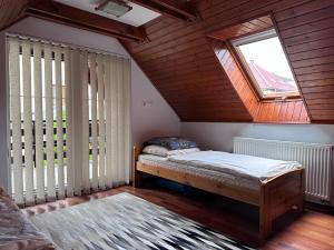 a bedroom with a bed and a window in a attic at Village Light House in Omšenie