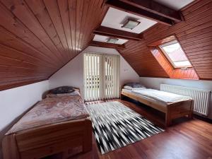 a attic room with two beds and a window at Village Light House in Omšenie